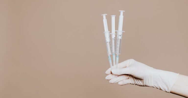 Person Holding Three Syringes with Medicine